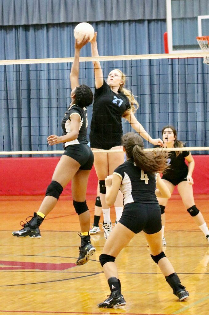 Pleasant Valley's Blakely Malsy (24) meets Oxford's Nyia Archie at the net for a block.