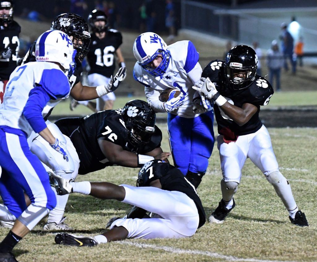 Jordan Montgomery wraps up White Plains' Charles Huey. Montgomery was a force on offense and defense in his final Wellborn football game Thursday night. (Photos by B.J. Franklin/GungHo Photos)