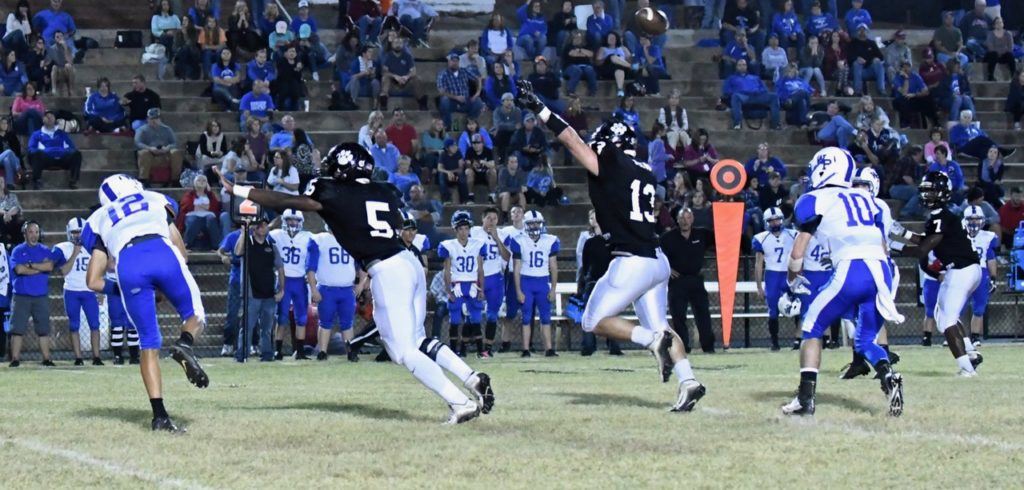 Wellborn's JaMyron Curry (5) and Kane Pitts (13) putting layers of pressure on White Plains quarterback James Bannister. The Wellborn defense recorded five sacks and scored three straight touchdowns.