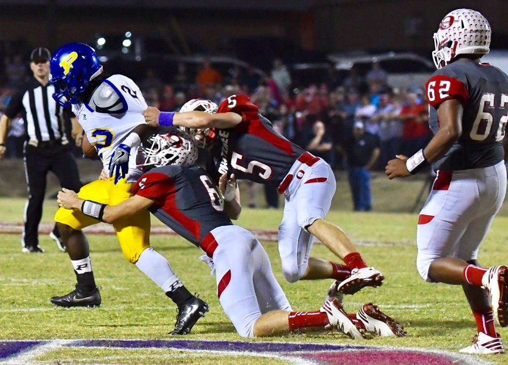 Piedmont's Lee Stanley fights to break the grasp of Ohatchee's Roger Widgeon (5) and Anthony Alward. Stanley broke off a 60-yard touchdown run in the second quarter.