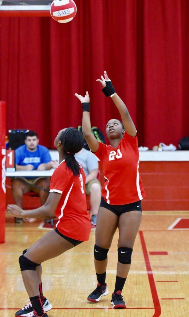 Saks' Miracle Dennard (20) makes a play on a ball early in the Lady Wildcats' match with Anniston. On the cover, Saks coach Randy Law watches the action. (Photos by B.J. Franklin/GungHo Photos)