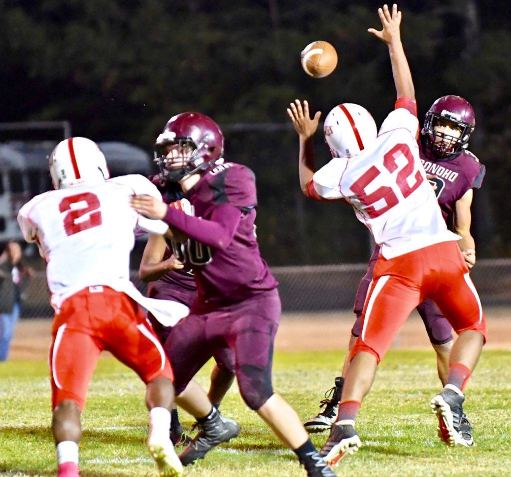 Donoho quarterback Garrett Steed tries to throw a pass around the pressure of Wadley lineman Chris Hodges.