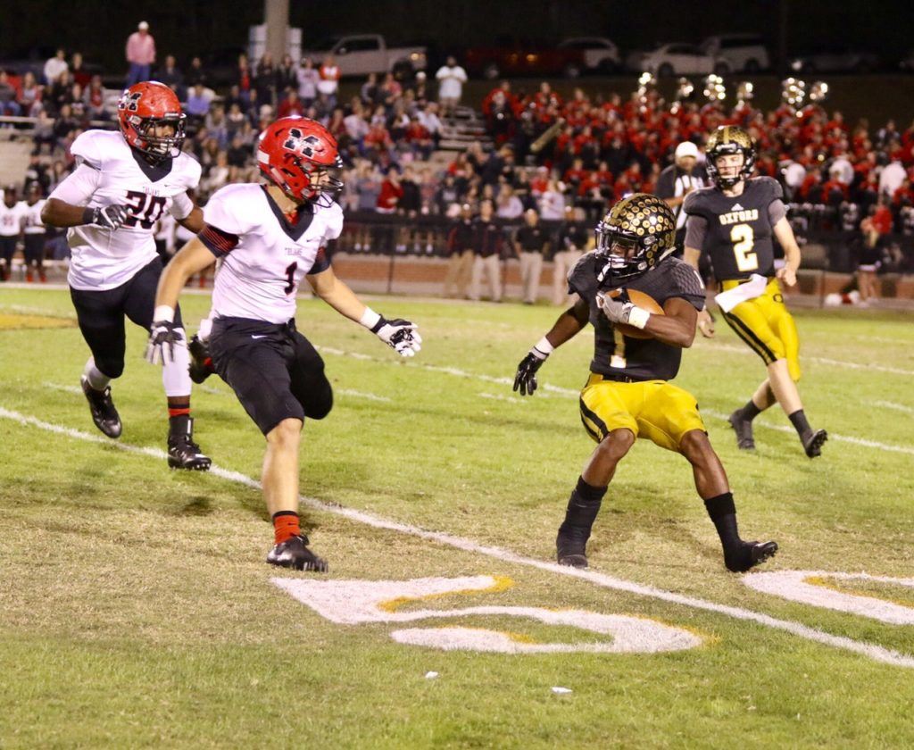 Tyetus Smith-Lindsey (1) looks to make a move against two oncoming Muscle Shoals defenders. Smith-Lindsey scored Oxford's first touchdown. On the cover, Oxford defenders Cross Davis (19) and Clay Webb (75) try to run down a Muscle Shoals ballcarrier. (Photo by Kristen Stringer/Krisp Pics Photography)
