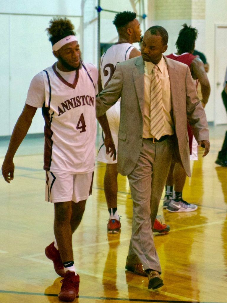 New Anniston basketball coach Torry Brown helps Marrio Dobbins back to the bench after the senior guard took an hard spill driving to the basket right before halftime. Dobbins scored 13 of his team-high 18 points in the second half. (Photo by B.J. Franklin/GungHo Photos)