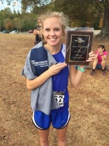 White Plains senior co-captain Alyssa Hudgins displays the Lady Wildcats' first-ever cross-country sectional championship plaque.