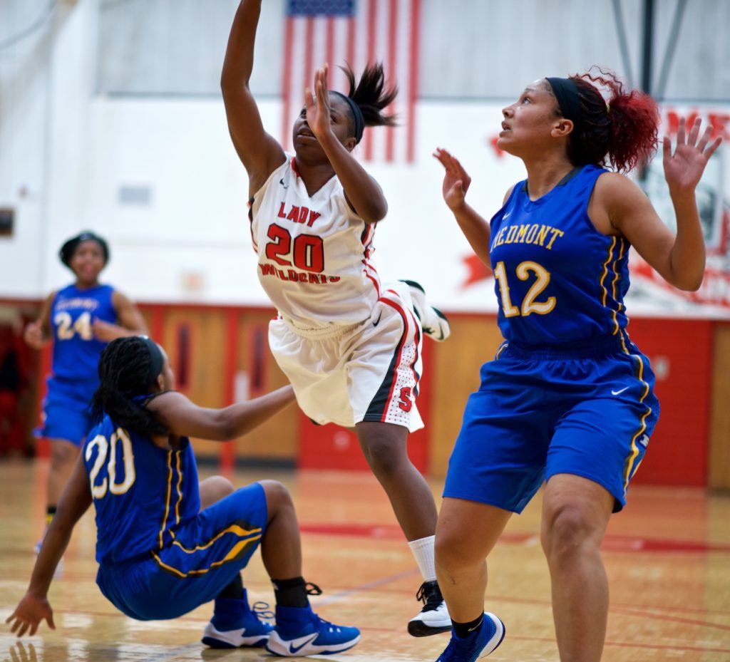 Saks' Miracle Dennard (20) goes flying between Piedmont's Kaitlyn Ridley and Breanna Brazier (12) late in Monday night's game. (Photo by B.J. Franklin/GungHo Photos)