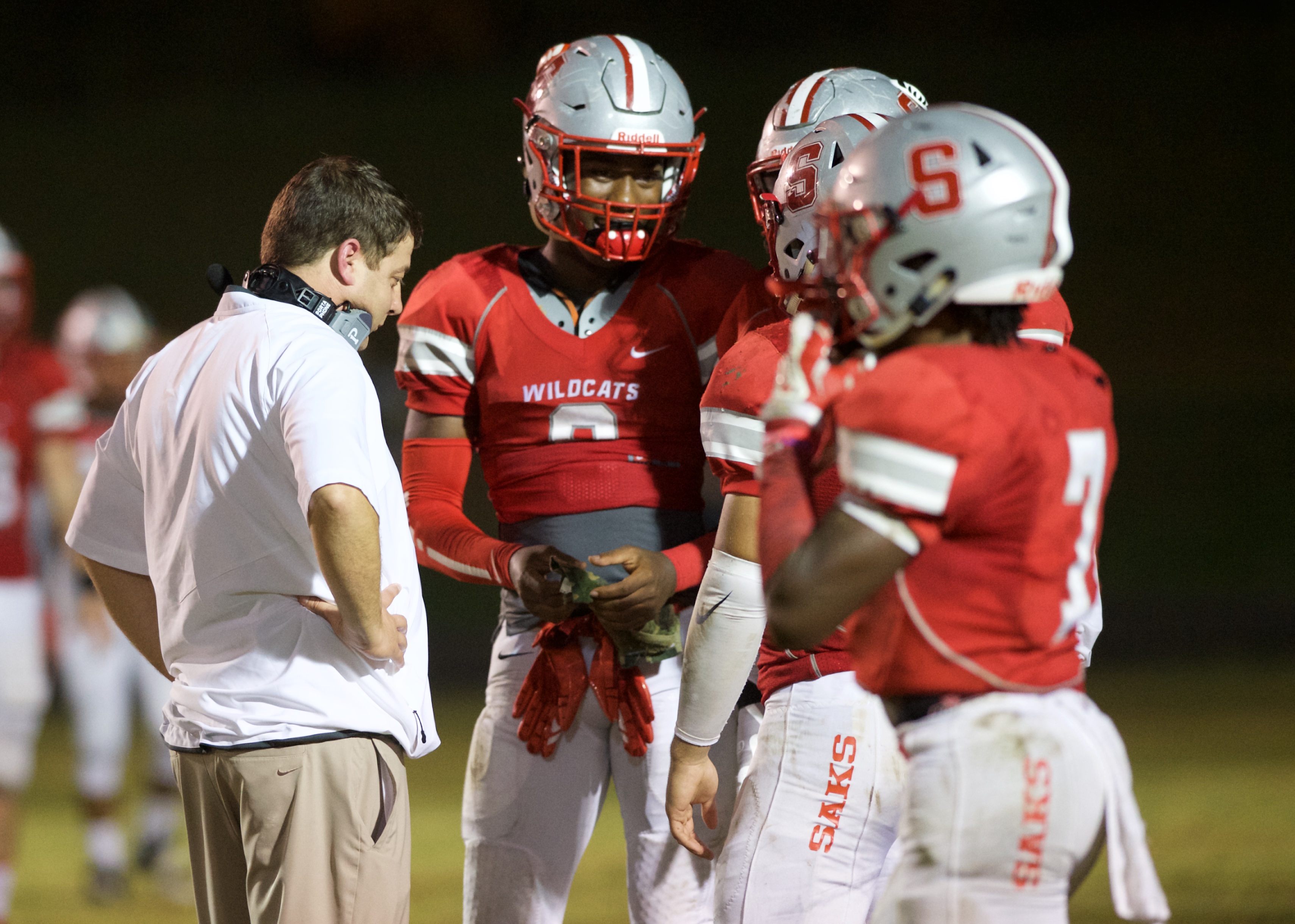 Ex-Saks quarterback Dee Bell (2) confers with coach Jonathan Miller and teammates during a timeout. (Photos by B.J. Franklin/GungHo Photos)