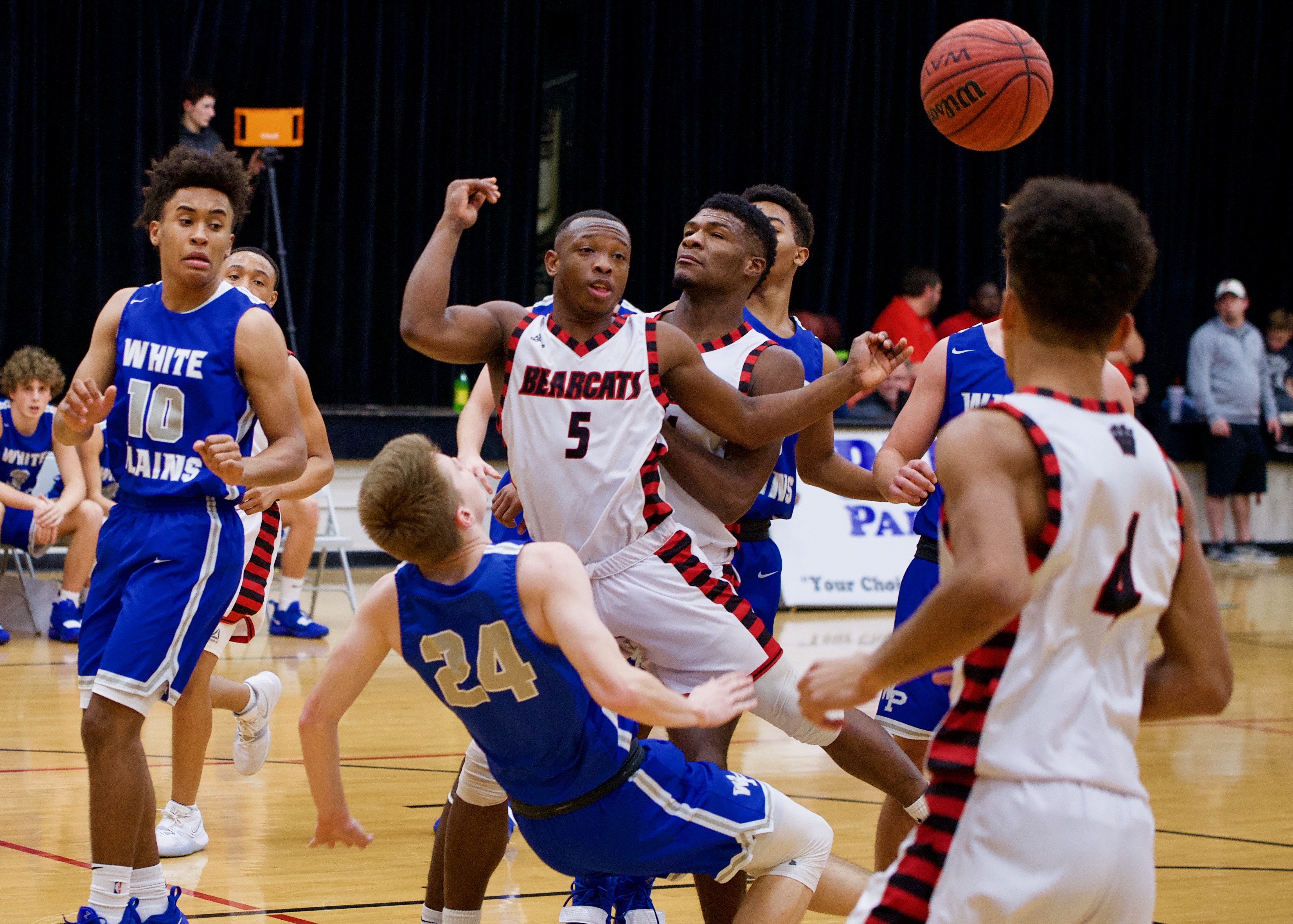 White Plains' Gavin Burrage (24) falls backwards after drawing a charge from Weaver's Shamar Spinks. (Photo by B.J. Franklin)