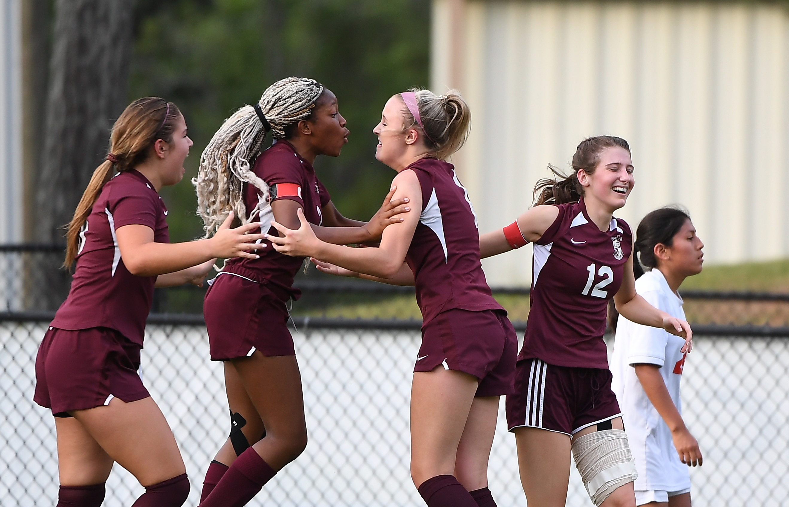 Donoho’s Tosin Sanusi embraces teammate Erin Turley after Turley gave the Lady Falcons the lead in their match with a goal 12 seconds before halftime. (Photo by B.J. Franklin)