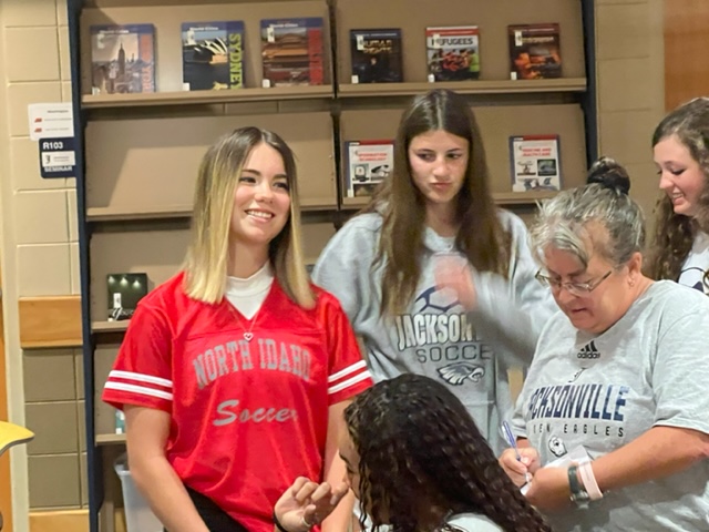 Olivia King (L) visits with coach Kim Darby and her Jacksonville soccer teammates today prior to formally signing to play at North Idaho College.