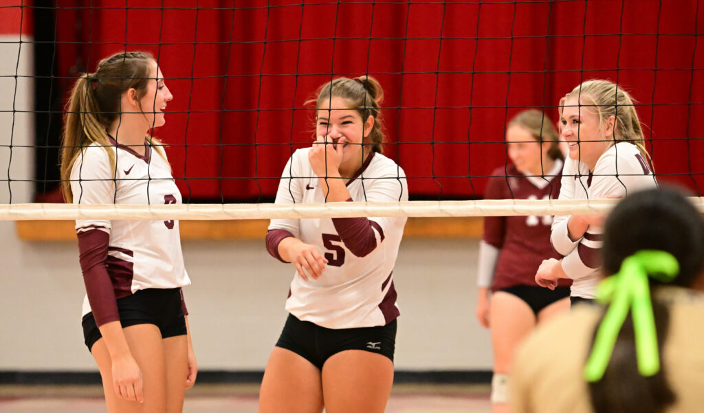 Donoho’s Sam Wakefield (5) and Lily Grace Draper (R) share a light moment with teammate Estella Connell during their match at Ohatchee Tuesday night. (Photo by B.J. Franklin)