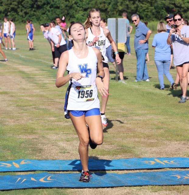 White Plains’ Maddyn Conn hits the wire just ahead of Oxford’s Katie Keur to win the Waffle House Invitational girls race Saturday. (Photo by Dana Stewart George). On the cover, Oxford’s Noah George and Evan Somers talk about their 1-2 finish in the boys race.