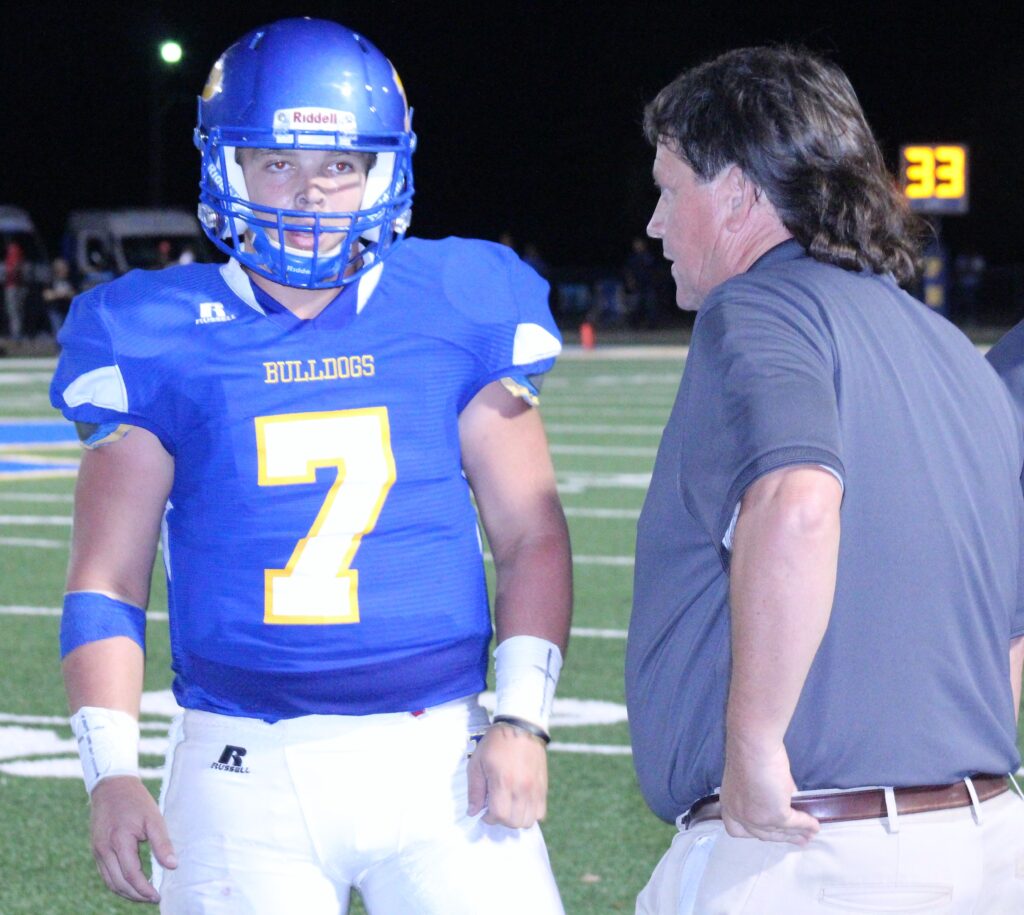 Piedmont quarterback Jack Hayes (7) talks over strategy with coach Steve Smith on the way to setting another all-time state record Thursday night. (Photo by Shannon Fagan)