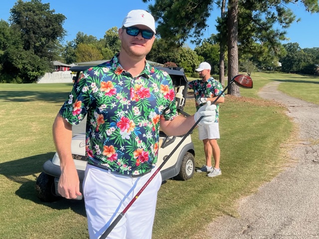Kevin Patton brings his colorful Hawaiian shirt to the 13th tee at Anniston Country Club Friday while partner Nick Pope makes his club selection back at the cart.