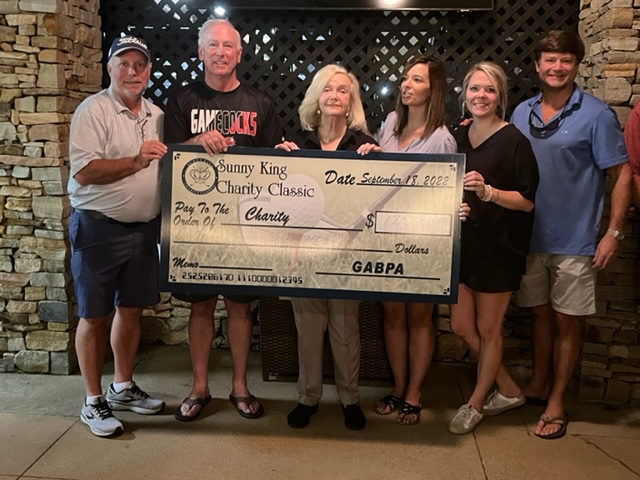 Presenting sponsor Patty King (C) and members of the Greater Anniston Business and Professionals Association display a check for $125,000 the Sunny King Charity Classic raised for its charities.