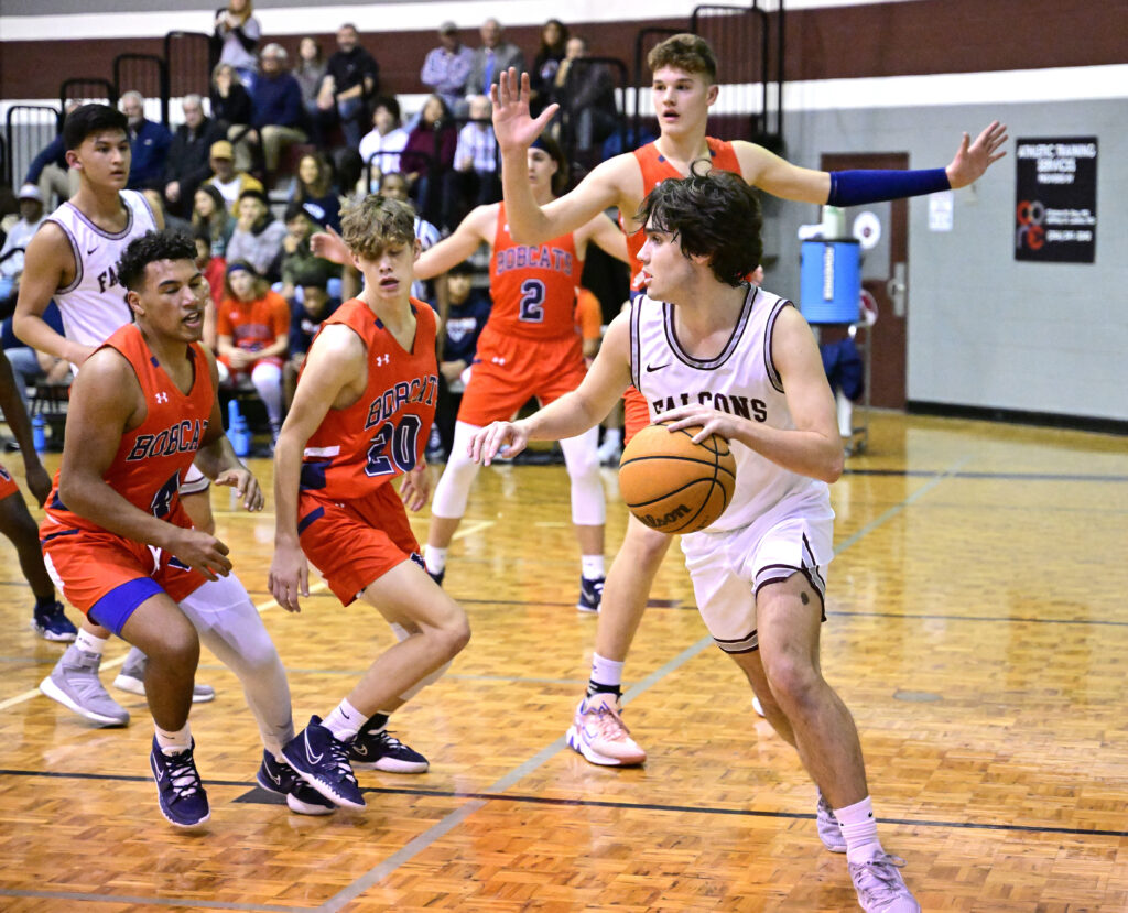 Donoho’s Drew Williamson looks for room to maneuver during Monday’s game against Woodland in which he scored his 1,000th career point. On the cover, the senior scorer is recognized for the feat. (Photos by B.J. Franklin)