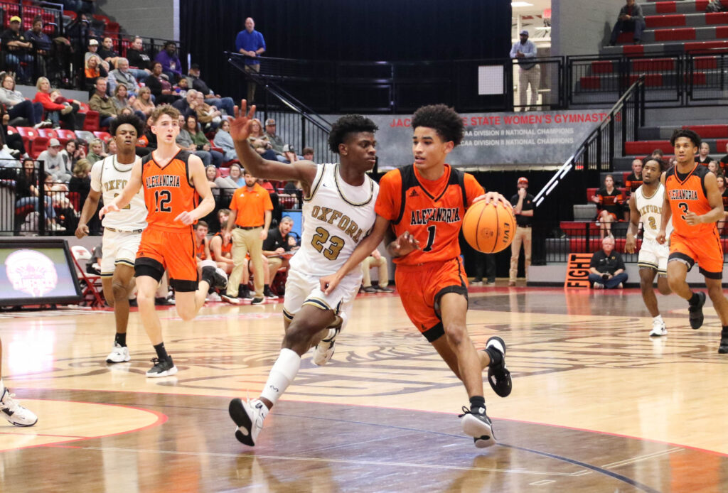 Cristian Gibson (23) tries to keep Alexandria’s Drake Davis from getting to the basket. The Oxford guard made three consecutive steals early in the second half to touch off the sequence that gave the Yellow Jackets control of the game. (Photo by Greg Warren)