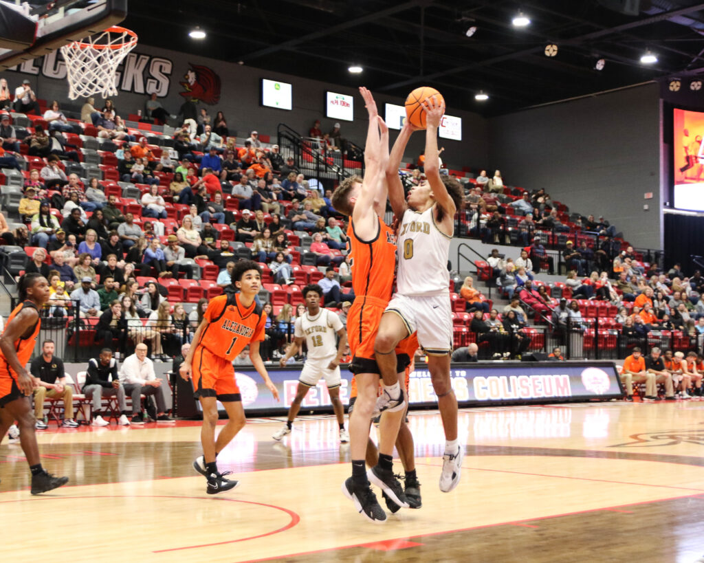 Oxford’s Jaylen Alexander (0) puts up a shot against the defense of Alexandria’s Kory Cargal during their Calhoun County boys semifinal game Thursday. Alexander scored 25 of his game-high 32 points in the second half of the Yellow Jackets’ victory. (Photos by Greg Warren)