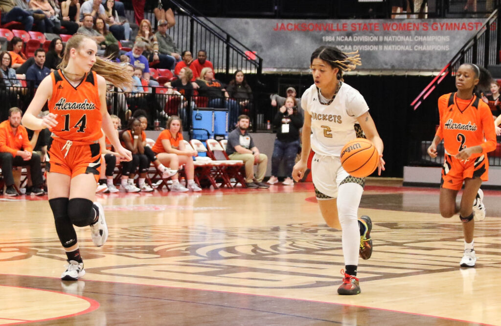 Oxford’s Justice Woods (middle) dribbles down the court as Alexandria’s Kailey Dickerson (left) and Jordyn Walker give chase during their Calhoun County semifinal Thursday in Pete Mathews Coliseum. (Photo by Greg Warren)