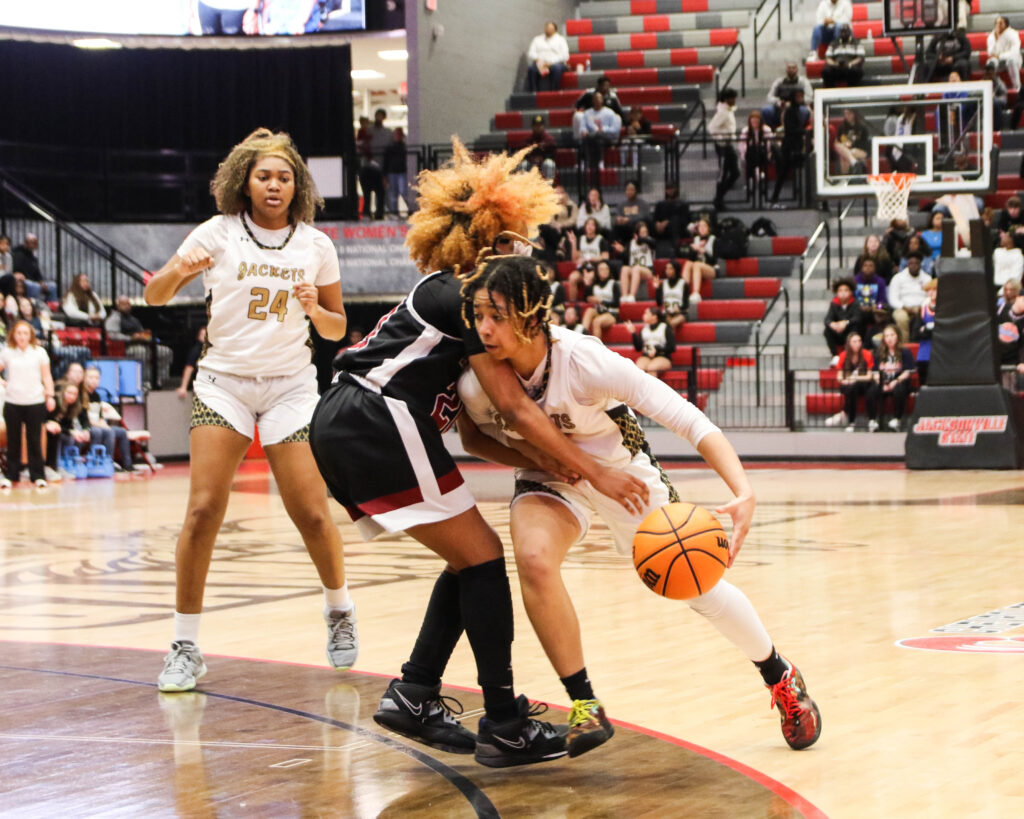 Anniston’s Jada Fomby (C) blocks Oxford guard Justice Woods’ path to the basket. (Photo by Greg Warren)