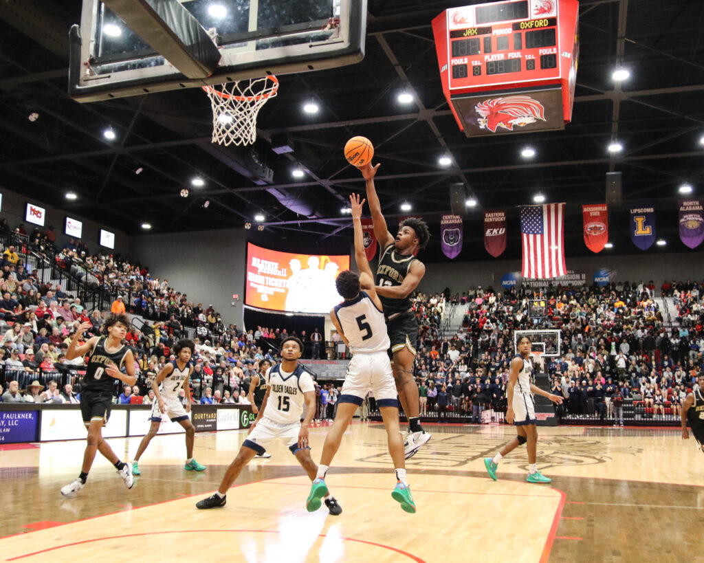 Oxford’s Jayden Lewis shoots as Jacksonville’s John Broom defends during Friday’s boys Calhoun County championship game in Pete Mathews Coliseum. Oxford won, 43-40. (Photo by Greg Warren)