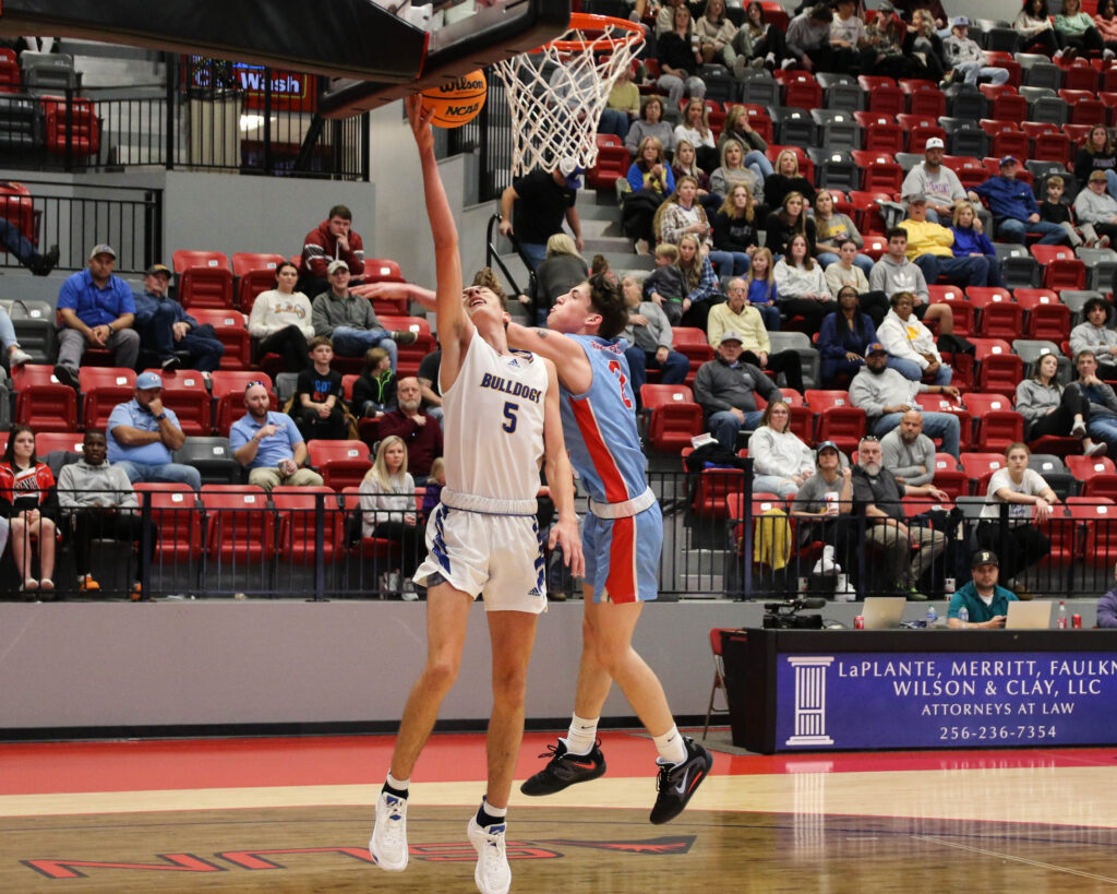 Piedmont’s Colton Proctor goes up for two as Pleasant Valley’s Jesse Gannaway defends during Monday’s Calhoun County tournament action in Pete Mathews Coliseum. (Photo by Greg Warren).