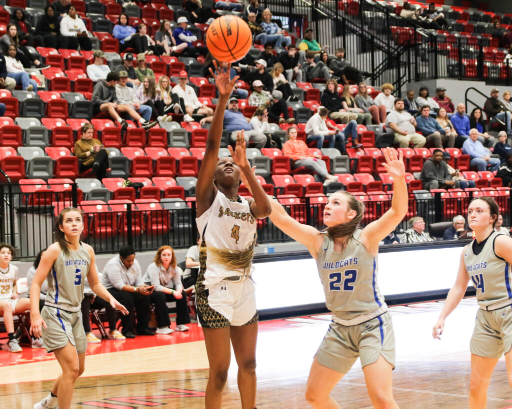 Oxford’s La’Mya McGrue shoots while White Plains’ Cooper Martin (left), Addison Bradley (22) and Hallie Williams defend during their Calhoun County quarterfinal Tuesday in Pete Mathews Coliseum. (Photo by Greg Warren)