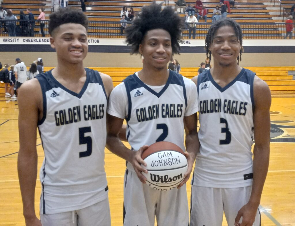 Jacksonville’s thousand-point trio of John Broom (left), Cam Johnson (center) and Caden Johnson celebrate Cam Johnson’s arrival into the thousand-point club Tuesday. He scored 28 points to lead Jacksonville in an 84-45 victory over Handley in their Class 4A Northeast subregional at Jacksonville. (Photo by Joe Medley)