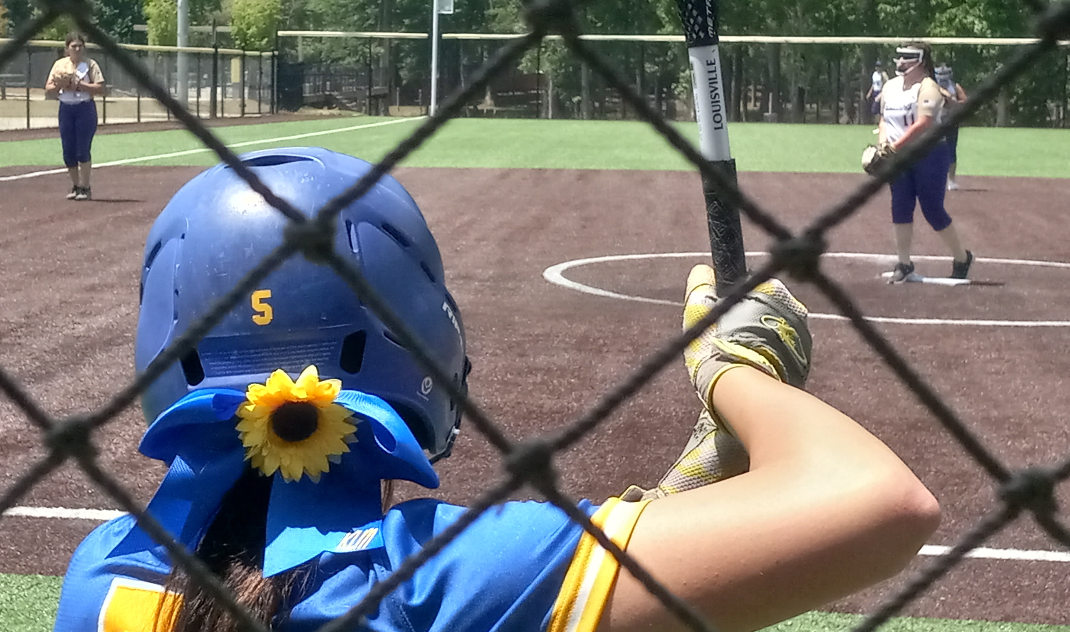 Piedmont players are wearing a special hair bow to honor Jacksonville State softball coach Jana McGinnis’ late daughter, Kinsey, who died last weekend after living 26 years with a rare genetic disorder. (Photo by Joe Medley)