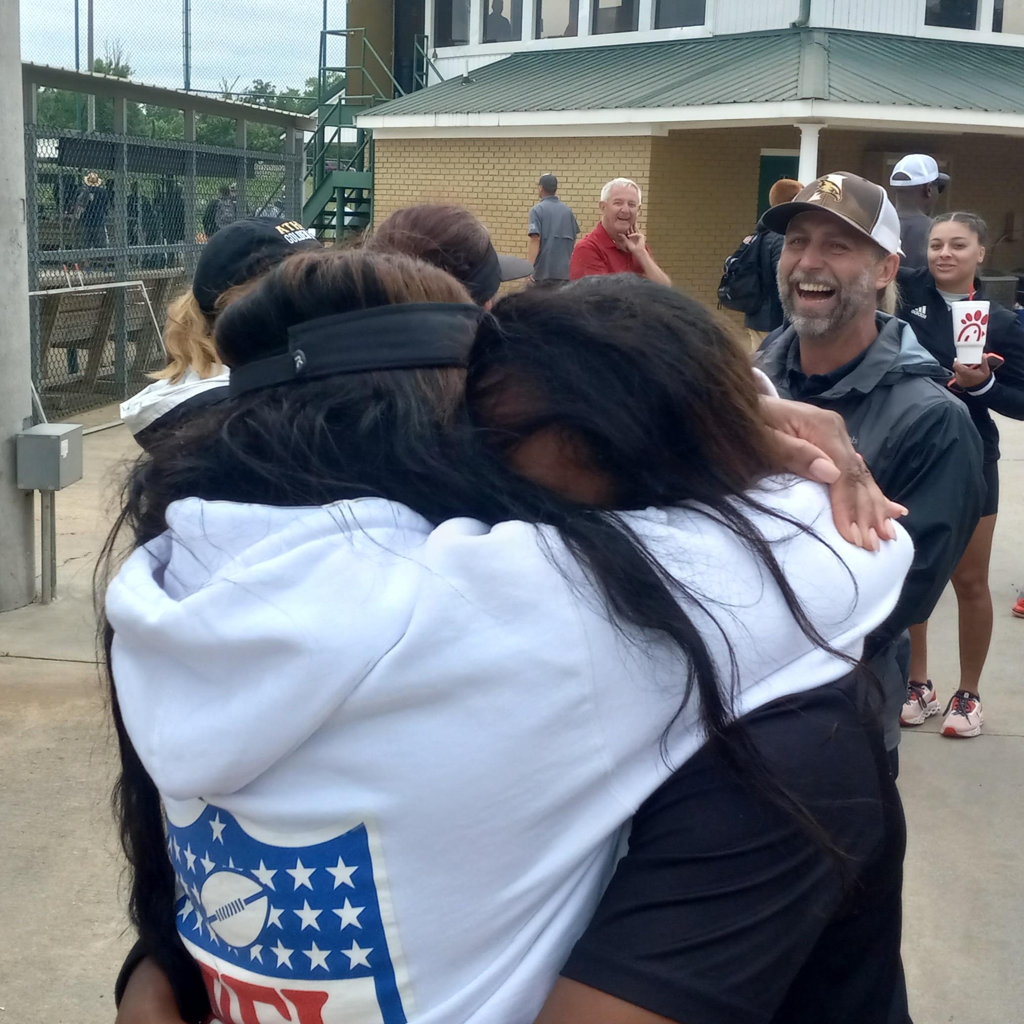 Oxford graduate Trachell Westbrook Kidd (left) hugs her daughter after Kristin Kidd hit a walk-off home run against her alma mater in Friday’s state-tournament action at Oxford Lake. (Photo by Joe Medley)