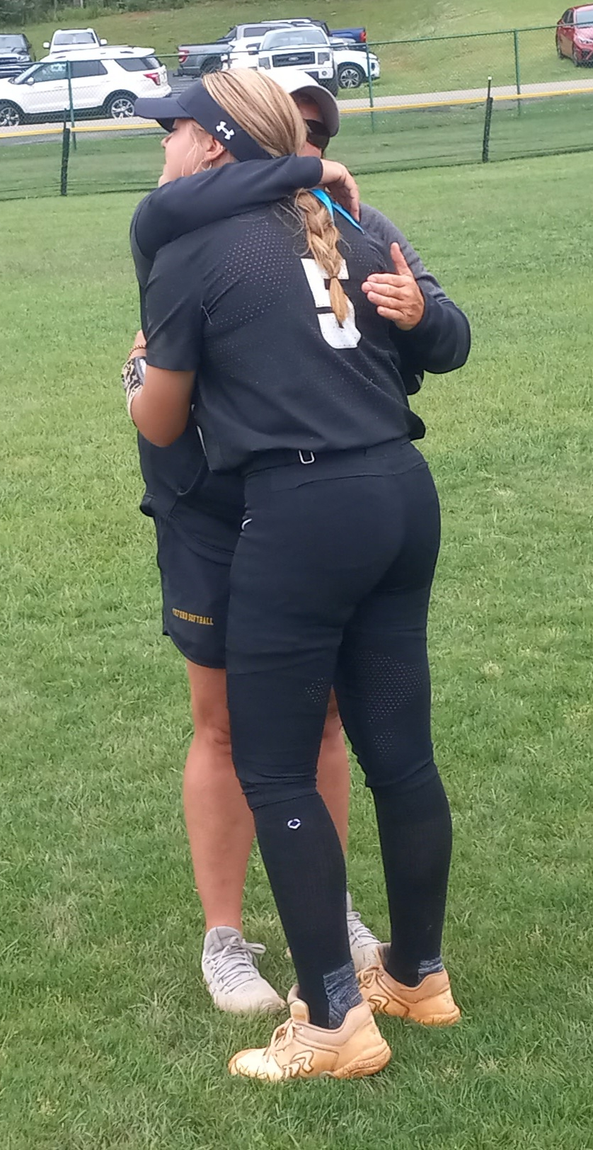 Oxford coach Wendy McKibbin and pitcher Berkley Mooney embrace after the Yellow Jackets lost to Athens in Friday’s state elimination game at Oxford Lake Park. (Photo by Joe Medley)