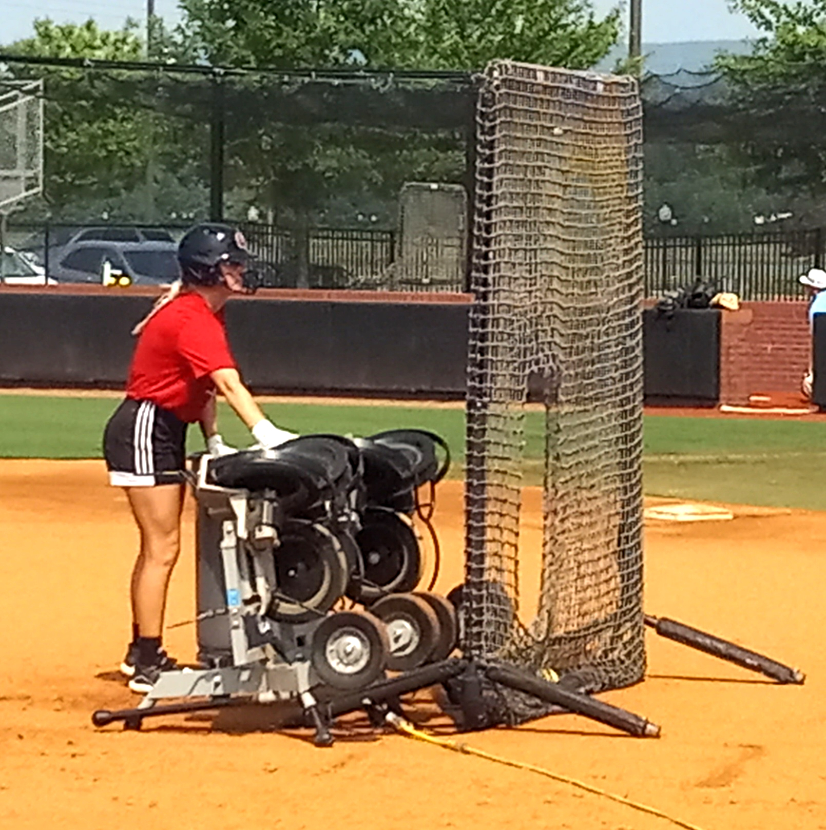 Former Alexandria High School and current Jacksonville State University player Ashley Phillips operates the pitching machine during Wednesday’s Smash It Sports Vipers practice at Choccolocco Park. (Photo by Joe Medley)