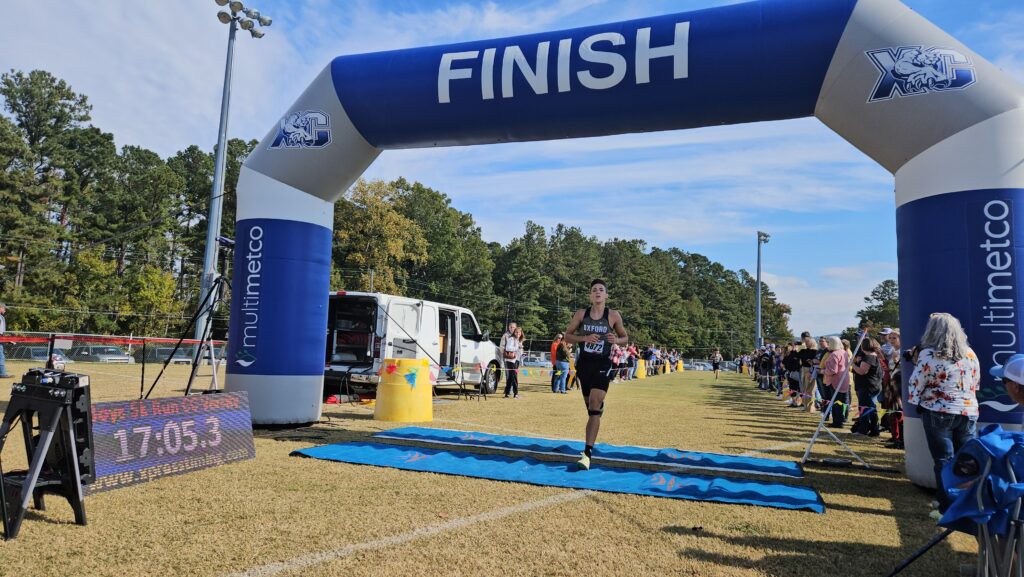 Oxford’s Isaac Williams crosses the finish line victorious in Thursday’s Calhoun County cross country meet at McClellan. (Photo by Joe Medley)