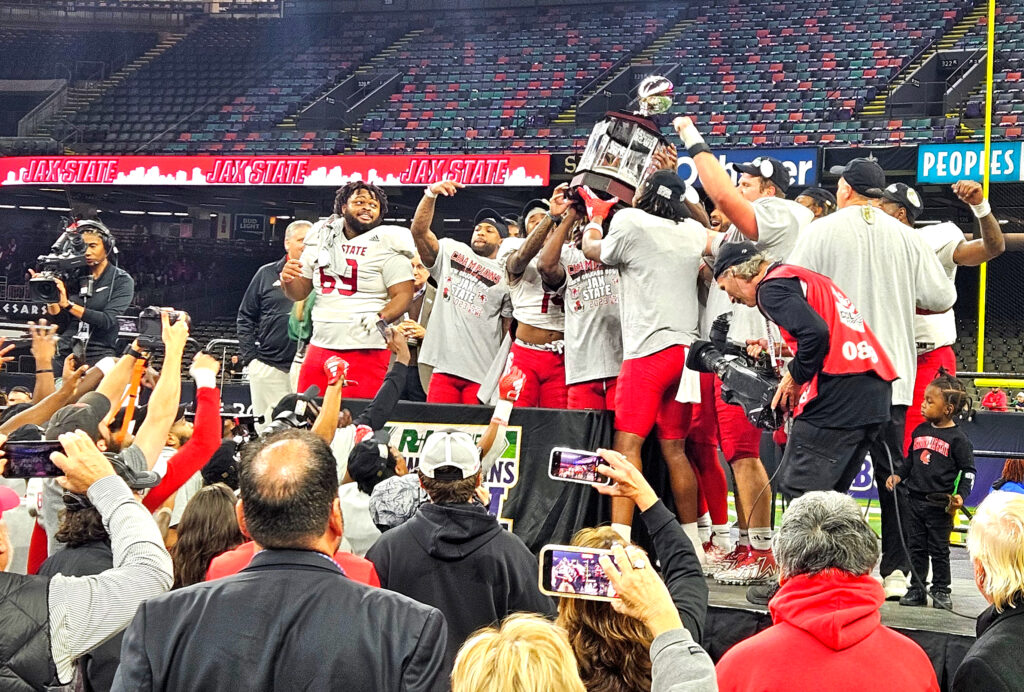 Jax State senior football players hoist the R+L Carriers New Orleans Bowl trophy after beating Louisiana 34-31 in overtime Saturday in the Caesers Superdome. (Photo by Joe Medley)