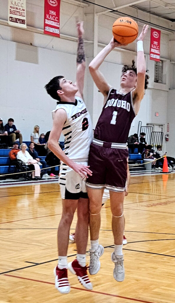 JCA’s Jesse Gannaway defends a shot by Donoho’s Jayden Cameron on Thursday. (Photo by Joe Medley)