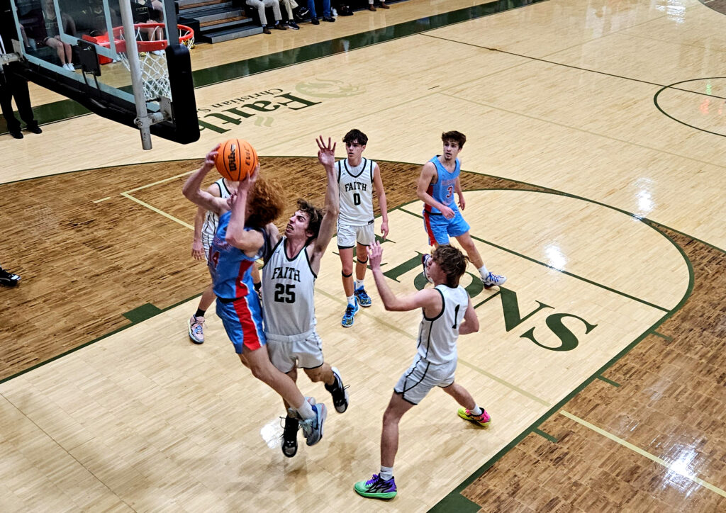 Pleasant Valley’s Braxton Salster goes up for a shot as Fath Christian’s Eli Robinson defends Friday at Faith. (Photo by Joe Medley)