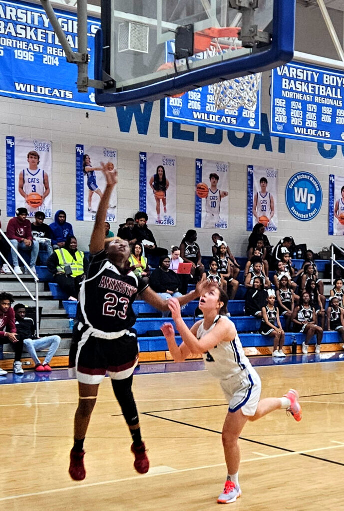 Anniston’s Serena Hardy goes in for a layup as White Plains’ Cooper Martin defends Thursday at White Plains. (Photo by Joe Medley)