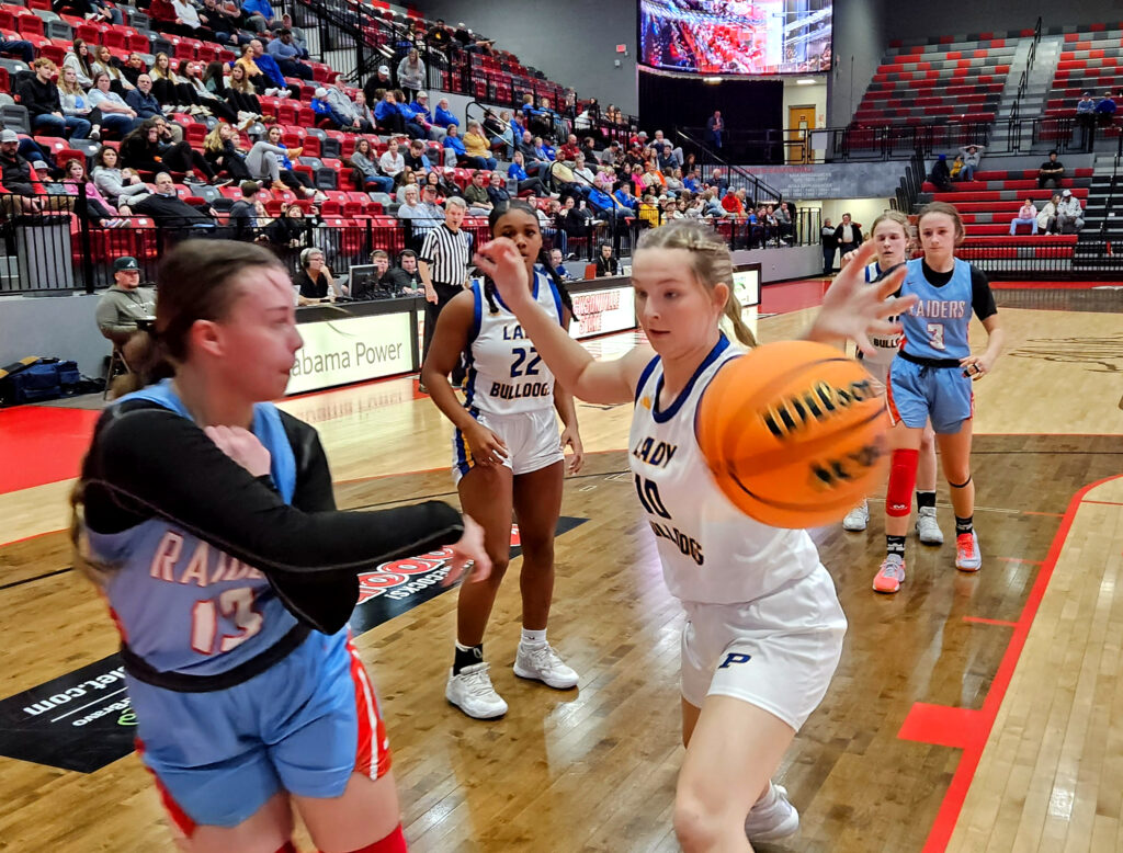 Pleasant Valley’s Haylie Lee attempts to save a ball in-bounds as Piedmont’s Carson Young defends during Monday’s Calhoun County tournament action in Pete Mathews Coliseum. (Photo by Joe Medley)