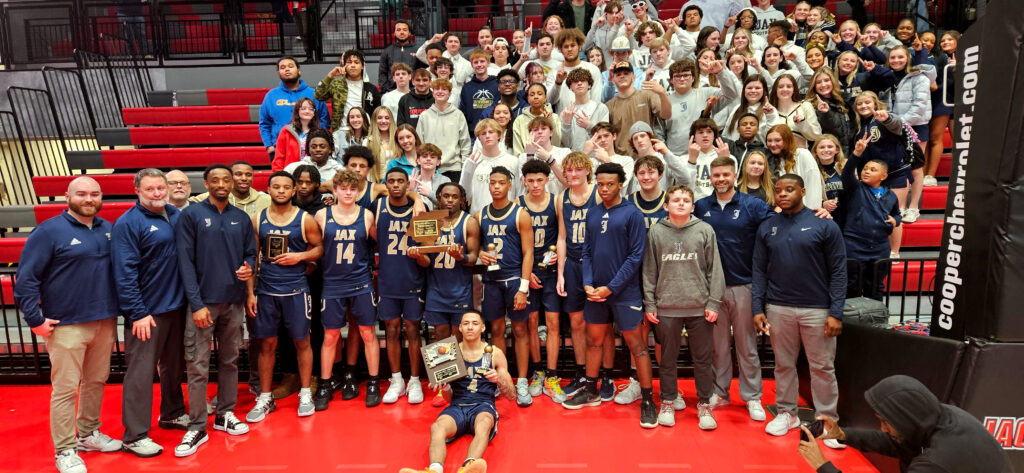 Jacksonville poses for a group picture with its student section after winning its first Calhoun County title in boys’ basketball since 1995 Friday in Pete Mathews Coliseum. (Photo by Joe Medley)