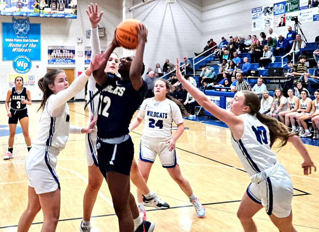 Jacksonville’s DeAsia Prothro goes up for two of her 11 points as White Plains’ Cooper Martin (left), Braeton Moran (24) and Abbie Dickeson defend Monday at White Plains. (Photo by Joe Medley)