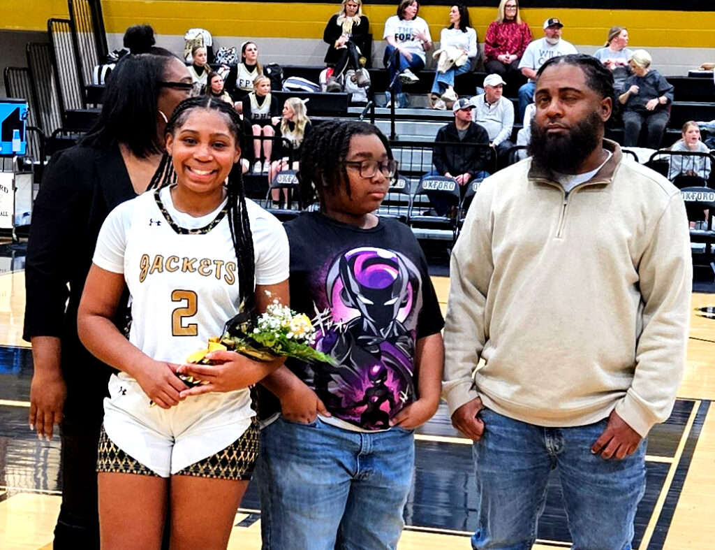 Senior JaMea Gaston and her family participate in senior-night activities Tuesday at Oxford. (Photo by Joe Medley)