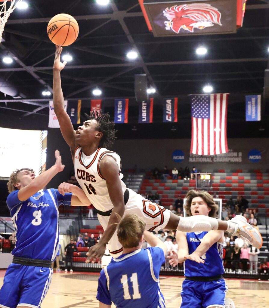 Alexandria’s Quendavion McDowell powers to the basket as White Plains’ Dylan Barksdale (3), Josh Wheeler (11) and Paul Laube defend during their Calhoun County quarterfinal Thursday at Pete Mathews Coliseum. (Photo by Stephen Gross/For East Alabama Sports Today)