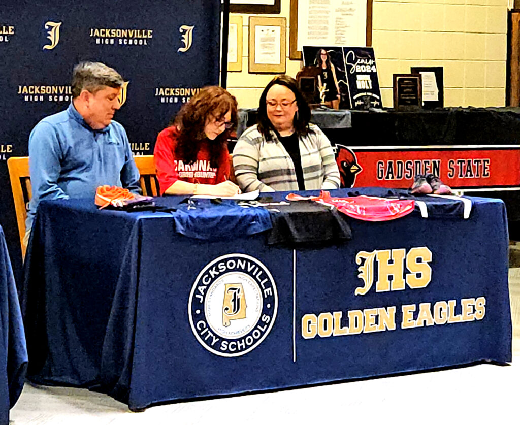 Maddie Holt with her parents at Jacksonville High’s National Signing Day ceremony. (Photo by Joe Medley)