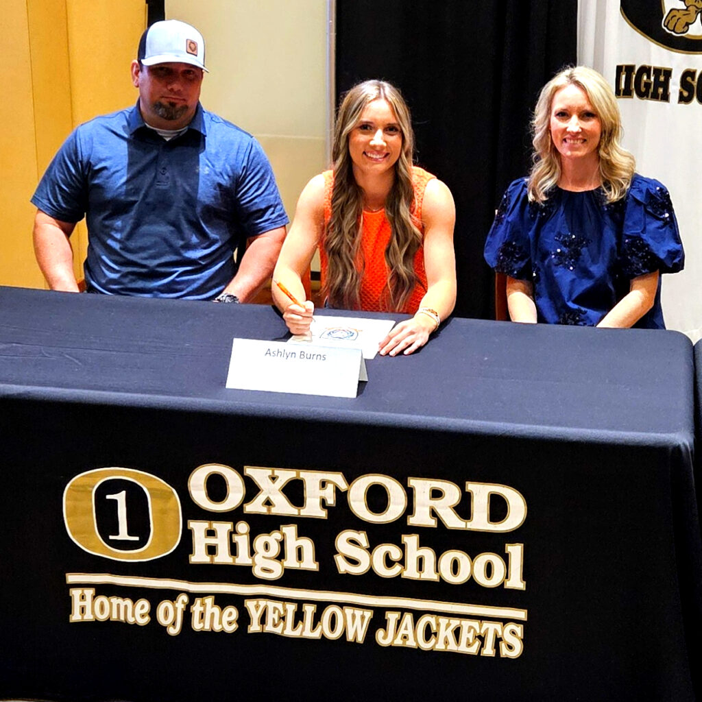 Ashlyn Burns with her parents at Monday’s signing ceremony.