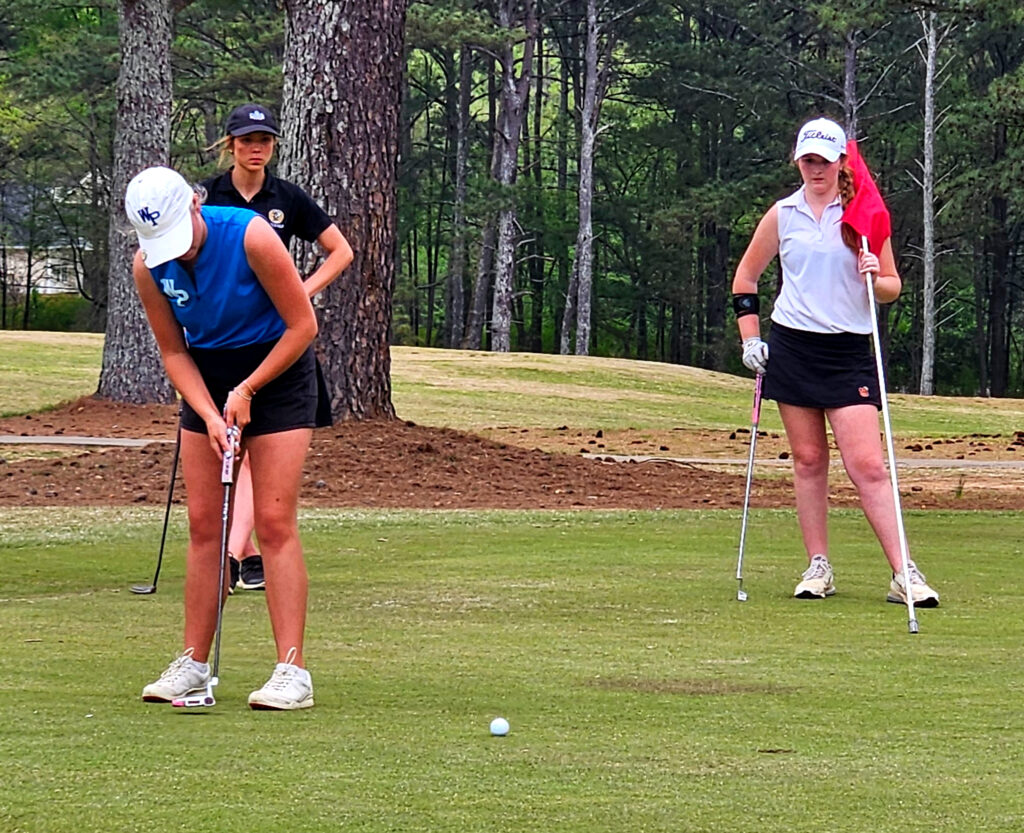White Plains’ Isabel Rogers putts to finish her first round of the Calhoun County tournament Monday at Pine Hill Country Club. The defending medalist shot 73 and leads by nine strokes. (Photo by Joe Medley)