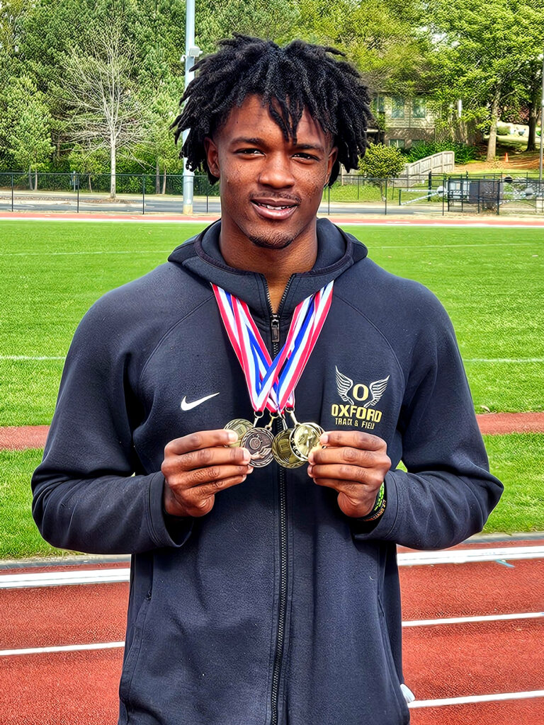 Oxford’s Antonio Hicks shows the four medals he earned during Wednesday’s Calhoun County meet at Choccolocco Park. (Photo by Joe Medley)