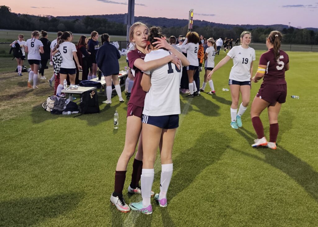 Donoho’s Lauren Wigley comforts Jacksonville’s Lexi Page after their epic Calhoun County championship match Thursday at Choccolocco Park (Photo by Joe Medley)